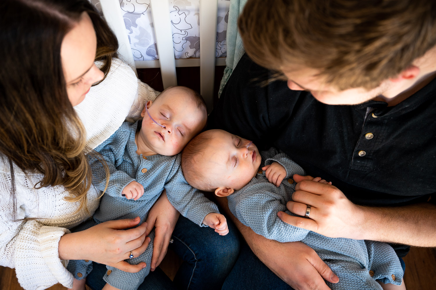parents hold their twin newborn boys
