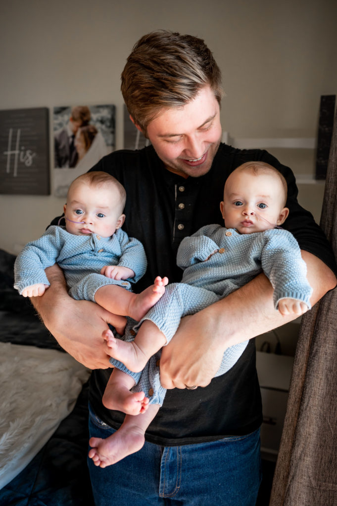 Dad holds twin newborns